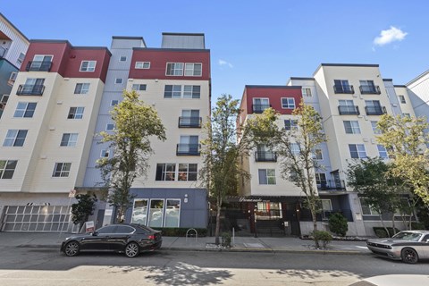 an apartment building on a city street with a car parked in front of it at Promenade at the Park Apartment Homes, Seattle, WA